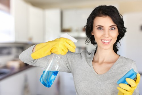 Cleaning worker handling disinfectant products safely near labelled containers