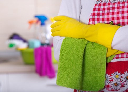 Staff member placing warning signs near a wet floor during cleaning