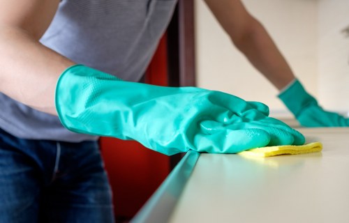 Professional cleaner maintaining stairwell and handrails in NW3